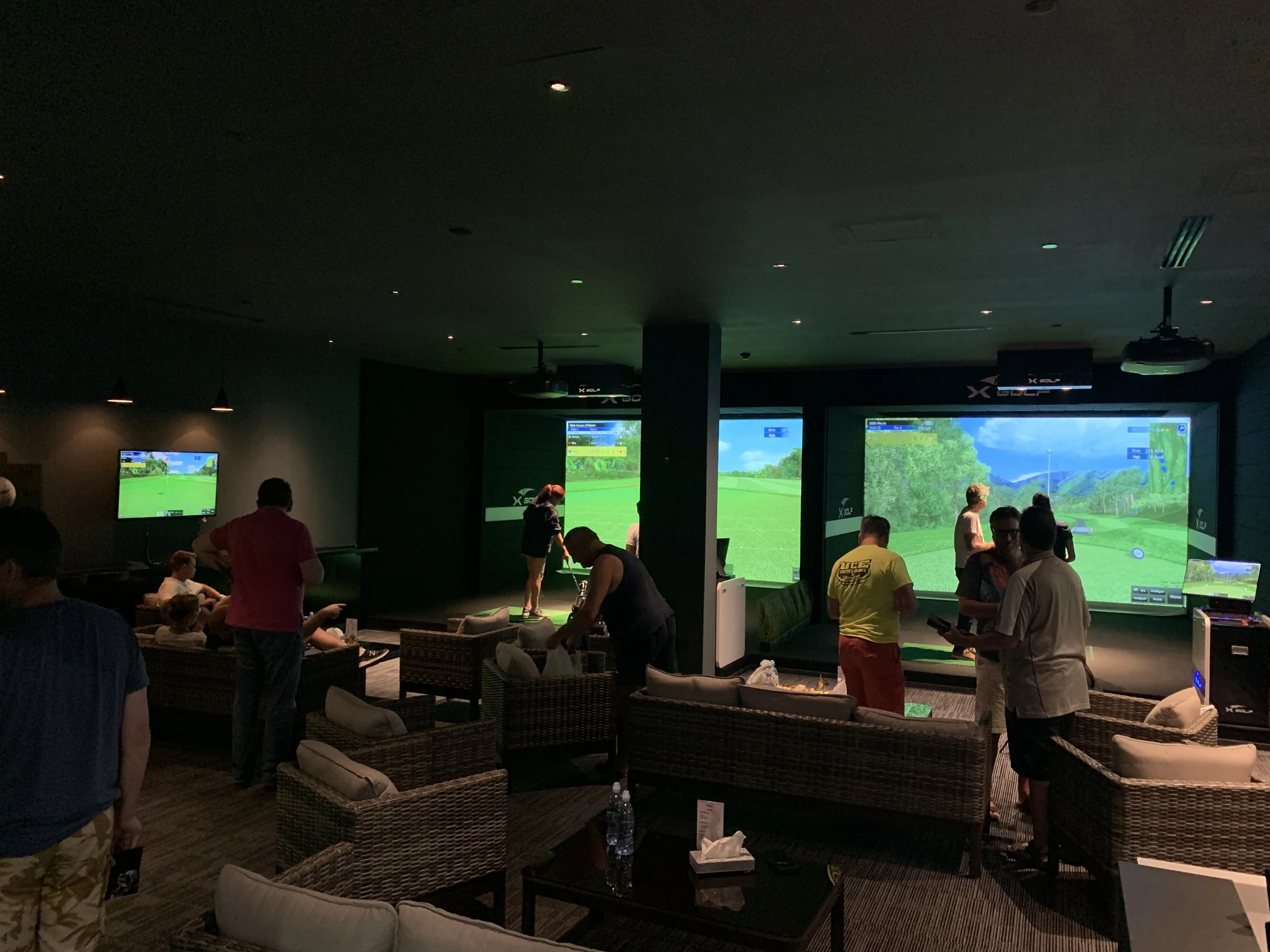 A real XGOLF installation with golf bays and a shared sofa lounge